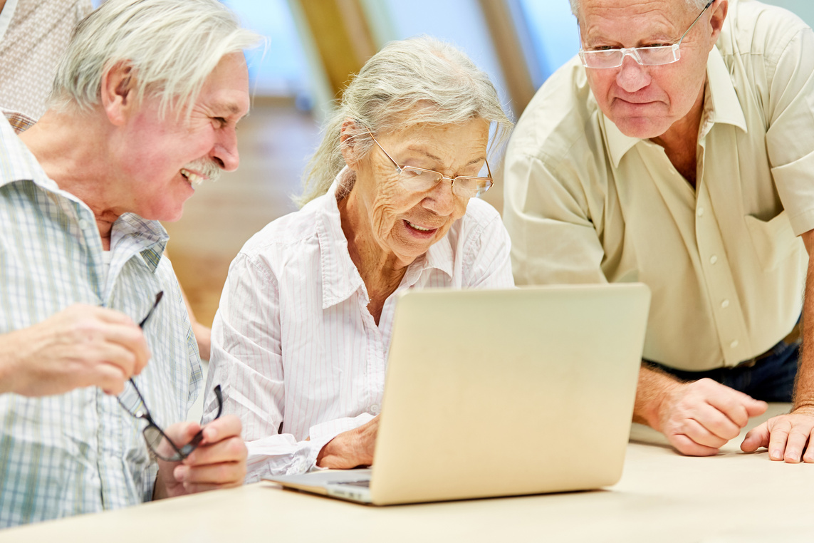 Senior Group at Laptop Computer Is Having Fun